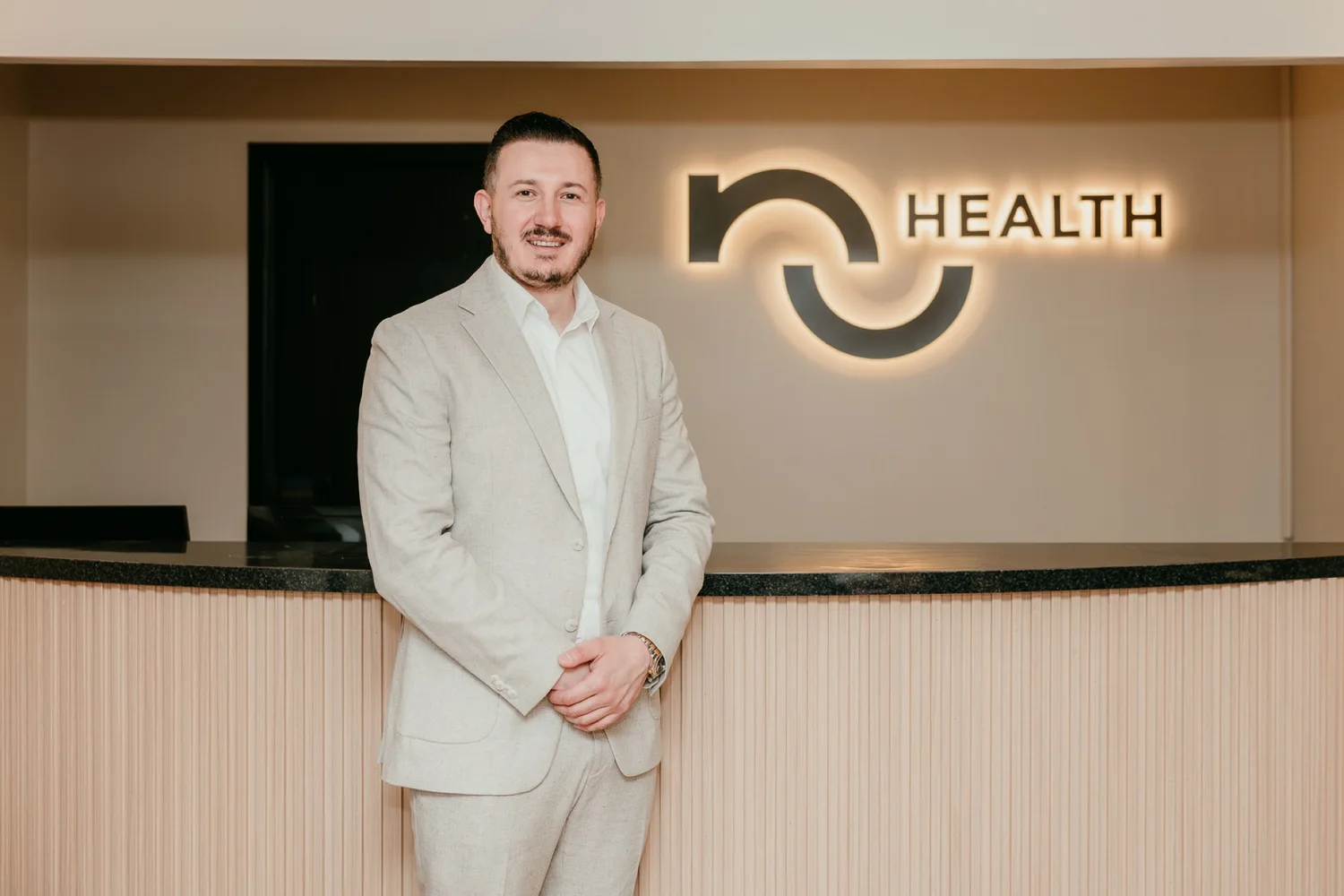 Kris Cutaj, MSPAS, PA-C, FAACM, at the reception desk of the NuHealth clinic in Royal Oak