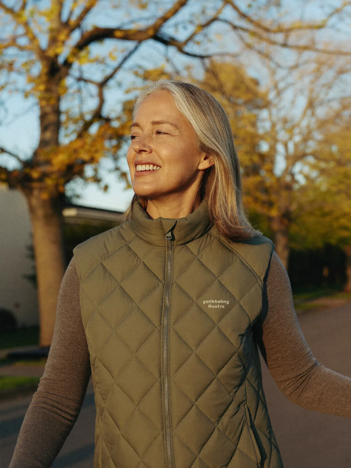 A woman on a brisk morning walk in warm light, clear-eyed and energetic — the steady vitality balanced hormones support